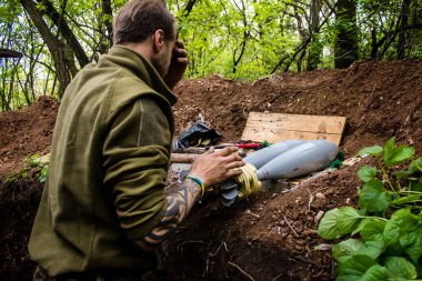 28. Topçu Taburu 'nun Ukraynalı askeri Bakhmut yakınlarındaki ormanın sıfır hattındaki bir Rus hedefine 120 mm' lik bir havan topu hazırlıyor. Rus ve Ukrayna orduları Donbass 'ta çarpışır, savaş şiddetlidir ve savaş...