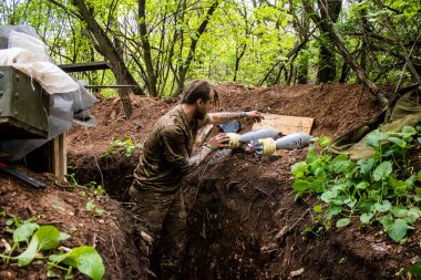 28. Topçu Taburu 'nun Ukraynalı askeri Bakhmut yakınlarındaki ormanın sıfır hattındaki bir Rus hedefine 120 mm' lik bir havan topu hazırlıyor. Rus ve Ukrayna orduları Donbass 'ta çarpışır, savaş şiddetlidir ve savaş...