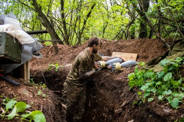 28. Topçu Taburu 'nun Ukraynalı askeri Bakhmut yakınlarındaki ormanın sıfır hattındaki bir Rus hedefine 120 mm' lik bir havan topu hazırlıyor. Rus ve Ukrayna orduları Donbass 'ta çarpışır, savaş şiddetlidir ve savaş...
