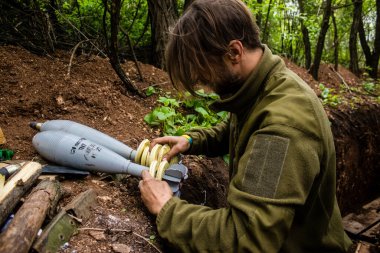 28. Topçu Taburu 'nun Ukraynalı askeri Bakhmut yakınlarındaki ormanın sıfır hattındaki bir Rus hedefine 120 mm' lik bir havan topu hazırlıyor. Rus ve Ukrayna orduları Donbass 'ta çarpışır, savaş şiddetlidir ve savaş...