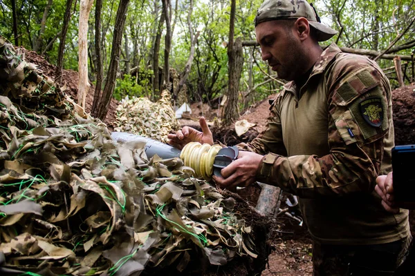 28. Topçu Taburu 'nun Ukraynalı askeri Bakhmut yakınlarındaki ormanın sıfır hattındaki bir Rus hedefine 120 mm' lik bir havan topu hazırlıyor. Rus ve Ukrayna orduları Donbass 'ta çarpışır, savaş şiddetlidir ve savaş...