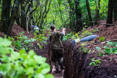 28. Topçu Taburu 'ndan Ukraynalı asker Bakhmut yakınlarındaki ormanın sıfır hattındaki Rus hedefine 120 mm' lik havan topu taşıyor. Rus ve Ukrayna orduları Donbass 'ta çarpışır, savaş şiddetlidir ve savaş...