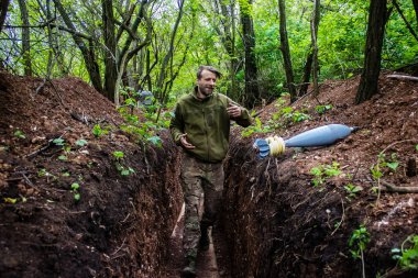 28. Topçu Taburu 'ndan Ukraynalı asker Bakhmut yakınlarındaki ormanın sıfır hattındaki Rus hedefine 120 mm' lik havan topu taşıyor. Rus ve Ukrayna orduları Donbass 'ta çarpışır, savaş şiddetlidir ve savaş...