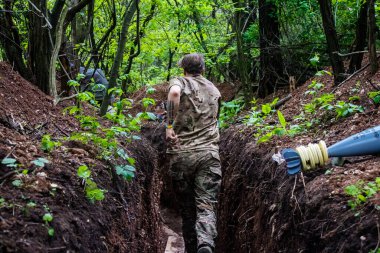 28. Topçu Taburu 'ndan Ukraynalı asker Bakhmut yakınlarındaki ormanın sıfır hattındaki Rus hedefine 120 mm' lik havan topu taşıyor. Rus ve Ukrayna orduları Donbass 'ta çarpışır, savaş şiddetlidir ve savaş...
