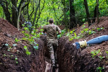 28. Topçu Taburu 'ndan Ukraynalı asker Bakhmut yakınlarındaki ormanın sıfır hattındaki Rus hedefine 120 mm' lik havan topu taşıyor. Rus ve Ukrayna orduları Donbass 'ta çarpışır, savaş şiddetlidir ve savaş...