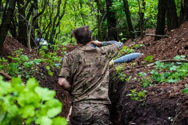 28. Topçu Taburu 'ndan Ukraynalı asker Bakhmut yakınlarındaki ormanın sıfır hattındaki Rus hedefine 120 mm' lik havan topu taşıyor. Rus ve Ukrayna orduları Donbass 'ta çarpışır, savaş şiddetlidir ve savaş...