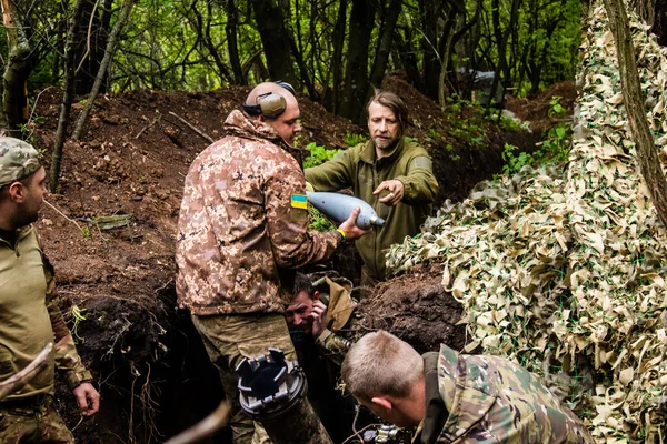 28. Topçu Taburu 'ndan Ukraynalı asker Bakhmut yakınlarındaki ormanın sıfır hattındaki Rus hedefine 120 mm' lik havan topu taşıyor. Rus ve Ukrayna orduları Donbass 'ta çarpışır, savaş şiddetlidir ve savaş...