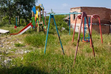 Izyum kasabasındaki hasarlı bir binanın önündeki terk edilmiş oyun parkı. Rus ordusunun öncelikli hedefi sivil altyapılardır..