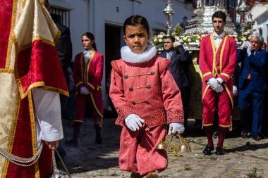 Corpus Christi geçit törenine katılan Katolik cemaatinden bir çocuk. İsa 'nın gerçek varlığını işlemek için asırlık bir Katolik inancı geleneği. Eski Carmona kasabasının dar sokaklarında dini törenler düzenleniyor.