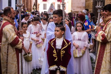 Corpus Christi geçit törenine katılan Katolik cemaatinden bir çocuk. İsa 'nın gerçek varlığını işlemek için asırlık bir Katolik inancı geleneği. Eski Carmona kasabasının dar sokaklarında dini törenler düzenleniyor.