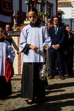 Corpus Christi geçit törenine katılan Katolik cemaatinden bir çocuk. İsa 'nın gerçek varlığını işlemek için asırlık bir Katolik inancı geleneği. Eski Carmona kasabasının dar sokaklarında dini törenler düzenleniyor.