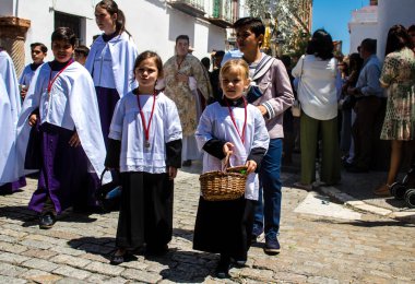 Corpus Christi geçit törenine katılan Katolik cemaatinden bir çocuk. İsa 'nın gerçek varlığını işlemek için asırlık bir Katolik inancı geleneği. Eski Carmona kasabasının dar sokaklarında dini törenler düzenleniyor.