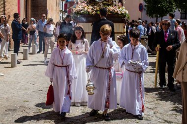 Corpus Christi geçit törenine katılan Katolik cemaatinden bir çocuk. İsa 'nın gerçek varlığını işlemek için asırlık bir Katolik inancı geleneği. Eski Carmona kasabasının dar sokaklarında dini törenler düzenleniyor.