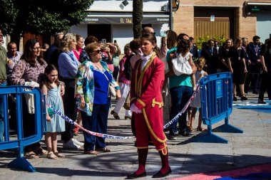 Corpus Christi geçit törenine katılan Katolik cemaatinden bir çocuk. İsa 'nın gerçek varlığını işlemek için asırlık bir Katolik inancı geleneği. Eski Carmona kasabasının dar sokaklarında dini törenler düzenleniyor.