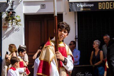 Corpus Christi geçit törenine katılan Katolik cemaatinden bir çocuk. İsa 'nın gerçek varlığını işlemek için asırlık bir Katolik inancı geleneği. Eski Carmona kasabasının dar sokaklarında dini törenler düzenleniyor.