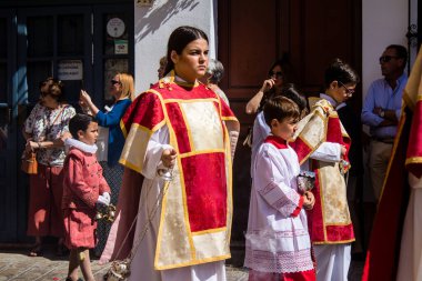 Corpus Christi geçit törenine katılan Katolik cemaatinden bir çocuk. İsa 'nın gerçek varlığını işlemek için asırlık bir Katolik inancı geleneği. Eski Carmona kasabasının dar sokaklarında dini törenler düzenleniyor.