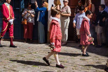 Corpus Christi geçit törenine katılan Katolik cemaatinden bir çocuk. İsa 'nın gerçek varlığını işlemek için asırlık bir Katolik inancı geleneği. Eski Carmona kasabasının dar sokaklarında dini törenler düzenleniyor.