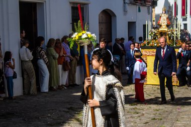 Corpus Christi geçit törenine katılan Katolik cemaatinden bir çocuk. İsa 'nın gerçek varlığını işlemek için asırlık bir Katolik inancı geleneği. Eski Carmona kasabasının dar sokaklarında dini törenler düzenleniyor.