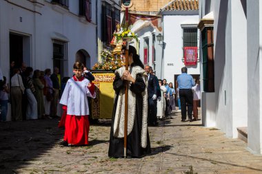 Corpus Christi geçit törenine katılan Katolik cemaatinden bir çocuk. İsa 'nın gerçek varlığını işlemek için asırlık bir Katolik inancı geleneği. Eski Carmona kasabasının dar sokaklarında dini törenler düzenleniyor.