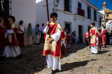 Corpus Christi geçit törenine katılan Katolik cemaatinden bir çocuk. İsa 'nın gerçek varlığını işlemek için asırlık bir Katolik inancı geleneği. Eski Carmona kasabasının dar sokaklarında dini törenler düzenleniyor.