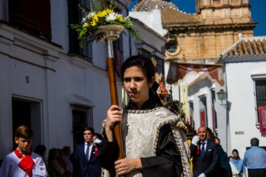 Corpus Christi geçit törenine katılan Katolik cemaatinden bir çocuk. İsa 'nın gerçek varlığını işlemek için asırlık bir Katolik inancı geleneği. Eski Carmona kasabasının dar sokaklarında dini törenler düzenleniyor.