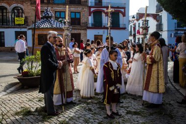 Corpus Christi geçit törenine katılan Katolik cemaatinden bir çocuk. İsa 'nın gerçek varlığını işlemek için asırlık bir Katolik inancı geleneği. Eski Carmona kasabasının dar sokaklarında dini törenler düzenleniyor.