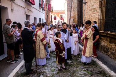 Corpus Christi geçit törenine katılan Katolik cemaatinden bir çocuk. İsa 'nın gerçek varlığını işlemek için asırlık bir Katolik inancı geleneği. Eski Carmona kasabasının dar sokaklarında dini törenler düzenleniyor.