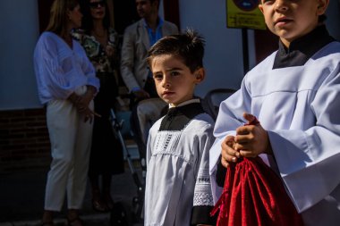 Corpus Christi geçit törenine katılan Katolik cemaatinden bir çocuk. İsa 'nın gerçek varlığını işlemek için asırlık bir Katolik inancı geleneği. Eski Carmona kasabasının dar sokaklarında dini törenler düzenleniyor.