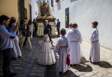 Corpus Christi geçit törenine katılan Katolik cemaatinden bir çocuk. İsa 'nın gerçek varlığını işlemek için asırlık bir Katolik inancı geleneği. Eski Carmona kasabasının dar sokaklarında dini törenler düzenleniyor.