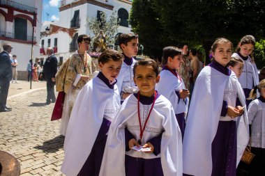 Corpus Christi geçit törenine katılan Katolik cemaatinden bir çocuk. İsa 'nın gerçek varlığını işlemek için asırlık bir Katolik inancı geleneği. Eski Carmona kasabasının dar sokaklarında dini törenler düzenleniyor.