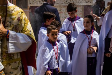 Corpus Christi geçit törenine katılan Katolik cemaatinden bir çocuk. İsa 'nın gerçek varlığını işlemek için asırlık bir Katolik inancı geleneği. Eski Carmona kasabasının dar sokaklarında dini törenler düzenleniyor.
