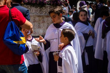 Corpus Christi geçit törenine katılan Katolik cemaatinden bir çocuk. İsa 'nın gerçek varlığını işlemek için asırlık bir Katolik inancı geleneği. Eski Carmona kasabasının dar sokaklarında dini törenler düzenleniyor.