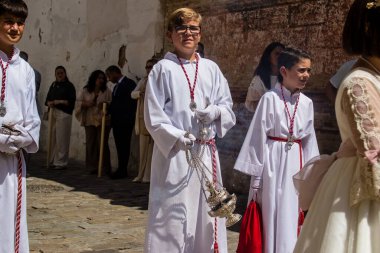 Corpus Christi geçit törenine katılan Katolik cemaatinden bir çocuk. İsa 'nın gerçek varlığını işlemek için asırlık bir Katolik inancı geleneği. Eski Carmona kasabasının dar sokaklarında dini törenler düzenleniyor.