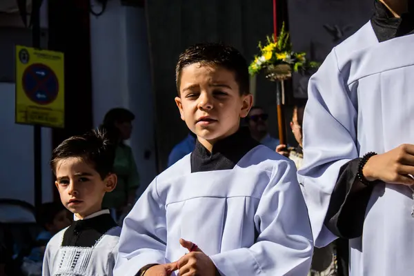 stock image Catholic parish child participating at the Corpus Christi procession, an age-old tradition of the Catholic faith to process the real presence of Jesus. Eucharistic processions take place in the narrow streets of the old town of Carmona which is reput