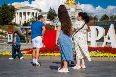 İnsanlar Kyiv 'deki Meydan Meydanı' na fotoğraf çektirmeye geliyor. Burası ünlü oldu ve şehrin tam göbeğinde yer alıyor. Kyiv hala tetikte olmasına rağmen, insanlar sirenlere ve R riskine rağmen normal yaşamaya çalışıyor.