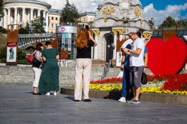 İnsanlar Kyiv 'deki Meydan Meydanı' na fotoğraf çektirmeye geliyor. Burası ünlü oldu ve şehrin tam göbeğinde yer alıyor. Kyiv hala tetikte olmasına rağmen, insanlar sirenlere ve R riskine rağmen normal yaşamaya çalışıyor.