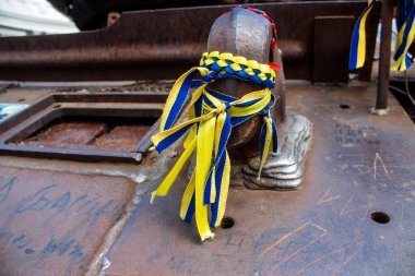 İnsanlar Ukrayna 'nın renginde bilezikler takmak için Ukrayna' nın savaşın başlangıcından beri yok ettiği Rus askeri teçhizatına geliyorlar. Bu imha edilmiş Rus askeri teçhizatının sunumu bir propaganda biçimi olarak kullanılıyor.