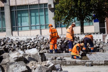 Bir füze saldırısının ardından Kyiv 'deki bir caddeyi onaran yol işçileri, Rus füzeleri ve insansız hava araçlarının hedefi caddeler ve binalar. NATO 'nun sağladığı etkin hava savunma sistemi sayesinde, saldırıları genellikle onlar saldırmadan etkisiz hale getiriliyor. 