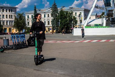 Kyiv, Ukrayna - 01 Ağustos 2023 Kyiv şehir merkezinde elektrikli scooter kullanan insanlar bunu her gün kullanıyor. Başkentte ulaşımın yollarından biridir..