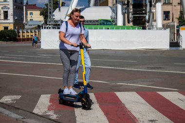 Kyiv, Ukrayna - 01 Ağustos 2023 Kyiv şehir merkezinde elektrikli scooter kullanan insanlar bunu her gün kullanıyor. Başkentte ulaşımın yollarından biridir..