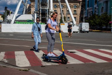 Kyiv, Ukrayna - 01 Ağustos 2023 Kyiv şehir merkezinde elektrikli scooter kullanan insanlar bunu her gün kullanıyor. Başkentte ulaşımın yollarından biridir..