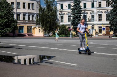 Kyiv, Ukrayna - 01 Ağustos 2023 Kyiv şehir merkezinde elektrikli scooter kullanan insanlar bunu her gün kullanıyor. Başkentte ulaşımın yollarından biridir..