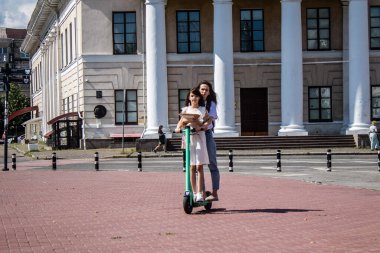 Kyiv, Ukrayna - 01 Ağustos 2023 Kyiv şehir merkezinde elektrikli scooter kullanan insanlar bunu her gün kullanıyor. Başkentte ulaşımın yollarından biridir..