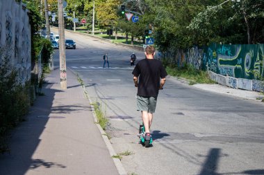Kyiv, Ukrayna - 01 Ağustos 2023 Kyiv şehir merkezinde elektrikli scooter kullanan insanlar bunu her gün kullanıyor. Başkentte ulaşımın yollarından biridir..