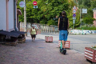 Kyiv, Ukrayna - 01 Ağustos 2023 Kyiv şehir merkezinde elektrikli scooter kullanan insanlar bunu her gün kullanıyor. Başkentte ulaşımın yollarından biridir..