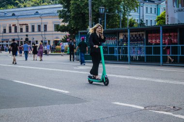 Kyiv, Ukrayna - 01 Ağustos 2023 Kyiv şehir merkezinde elektrikli scooter kullanan insanlar bunu her gün kullanıyor. Başkentte ulaşımın yollarından biridir..