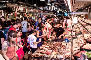 Barselona, İspanya - 28 Ağustos 2023 İspanya 'nın başkenti Barcelona' daki Boqueria gıda pazarında keyif çatan turistler.