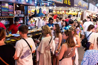Barselona, İspanya - 28 Ağustos 2023 İspanya 'nın başkenti Barcelona' daki Boqueria gıda pazarında keyif çatan turistler.