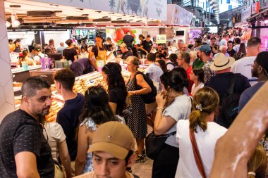 Barselona, İspanya - 28 Ağustos 2023 İspanya 'nın başkenti Barcelona' daki Boqueria gıda pazarında keyif çatan turistler.