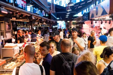 Barselona, İspanya - 28 Ağustos 2023 İspanya 'nın başkenti Barcelona' daki Boqueria gıda pazarında keyif çatan turistler.